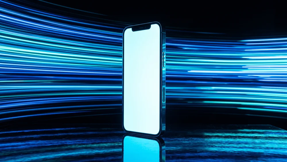 A smartphone standing upright with a blank glowing screen surrounded by streaks of blue light
