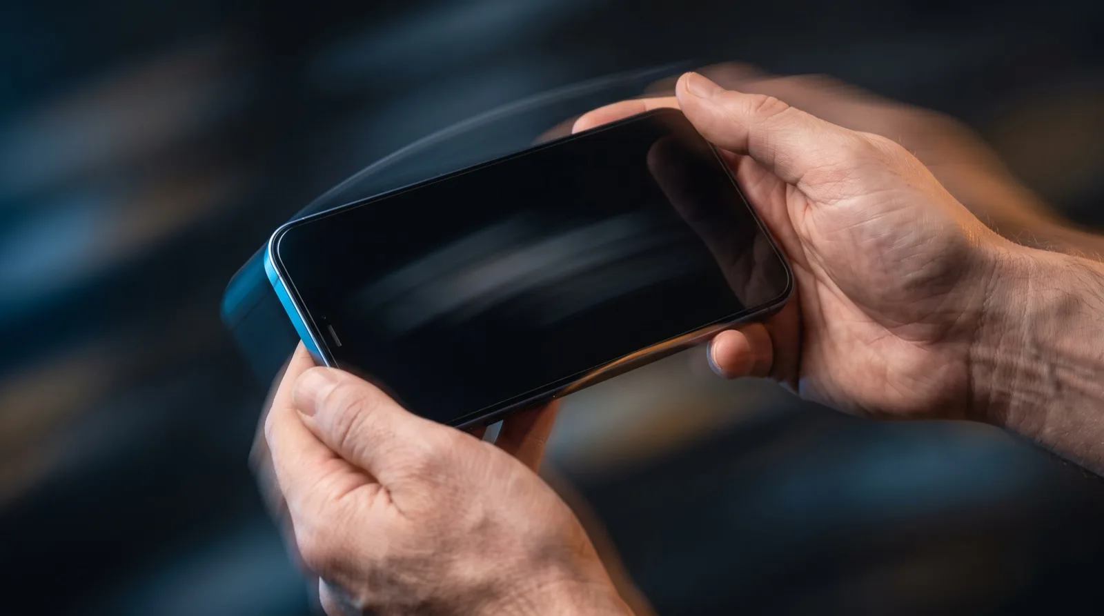 A smartphone tilted mid-motion in two hands, showing the movement gyroscope aiming relies on