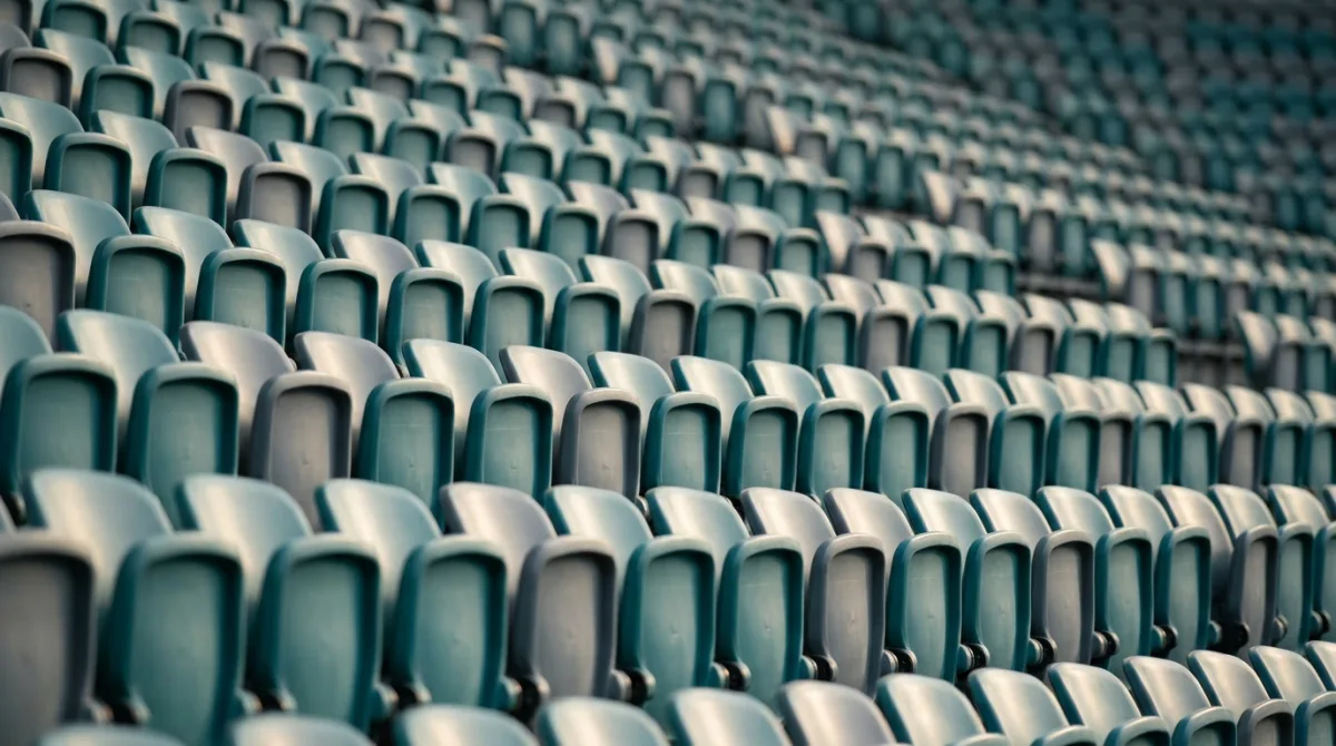 Rows of empty teal and grey stadium seats forming a repeating pattern