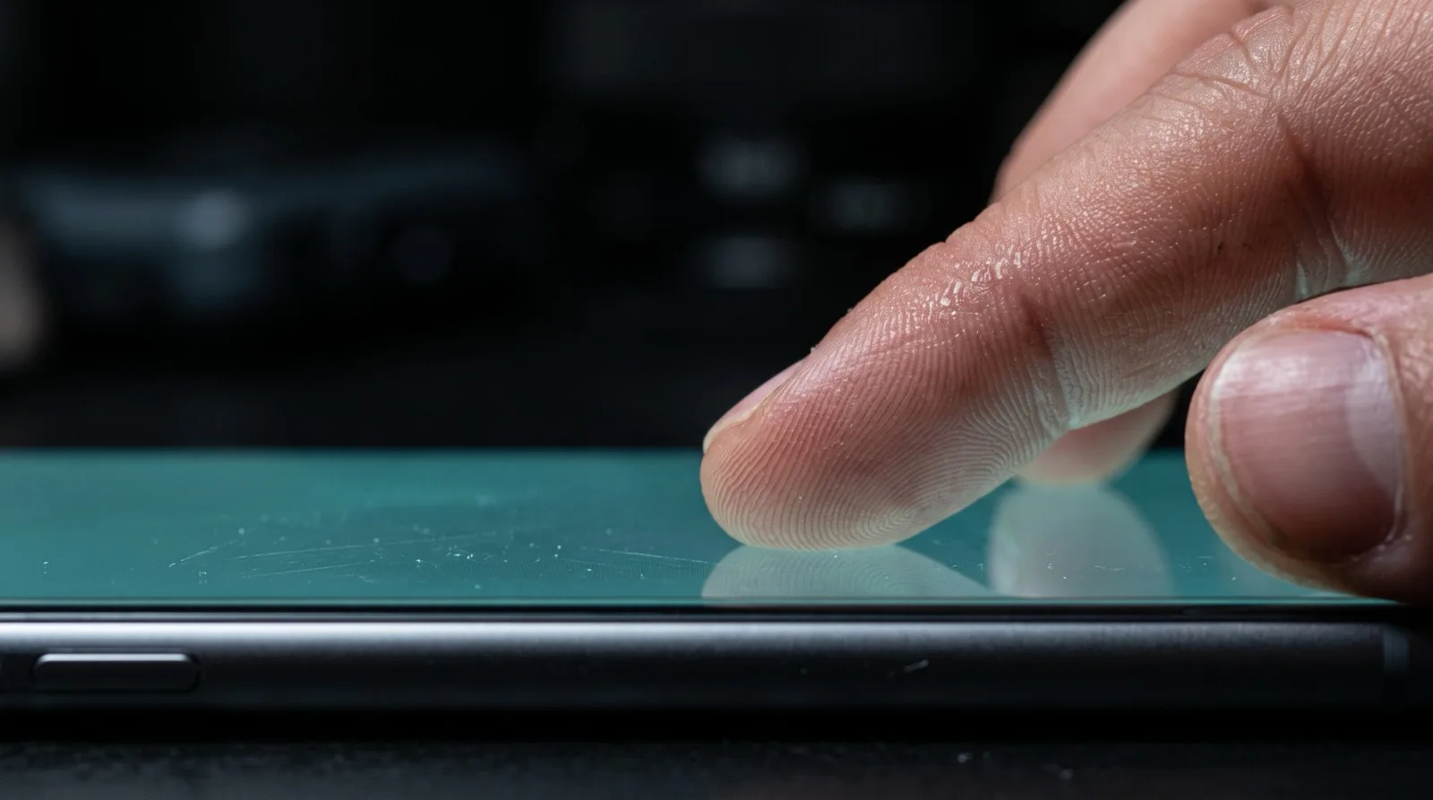 A fingertip resting on a smartphone screen, close up, suggesting fine sensitivity adjustment