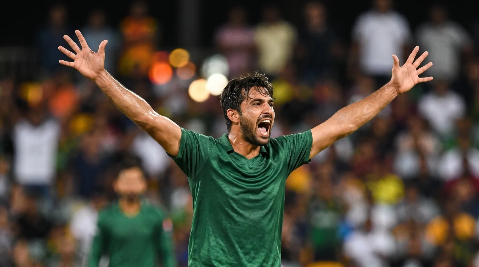 Fast bowler celebrating a wicket under floodlights at a T20 World Cup match