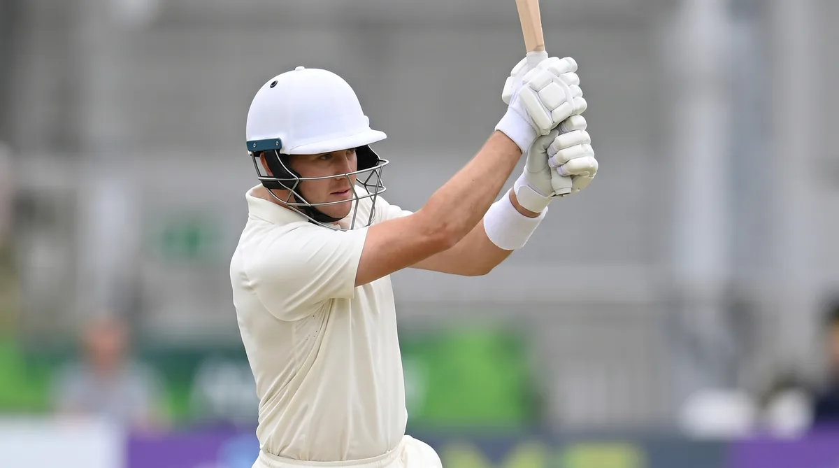 A batter in Test whites follows through on an attacking shot