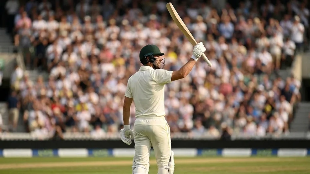 Batter in Test whites raises his bat to the crowd after a century